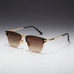 Sunglasses with gold and black frame on a gray background