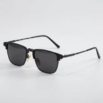Black frame sunglasses with gray film lenses on a dark gray background