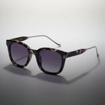 Sunglasses with tortoiseshell frame and dark gradient lenses on a white background
