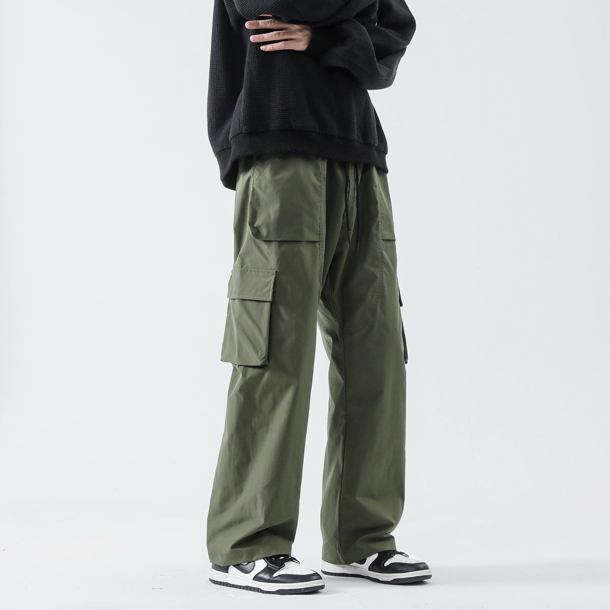 Men wearing loose straight solid color track pants in Black, Khaki, and Army Green for casual leisure wear
